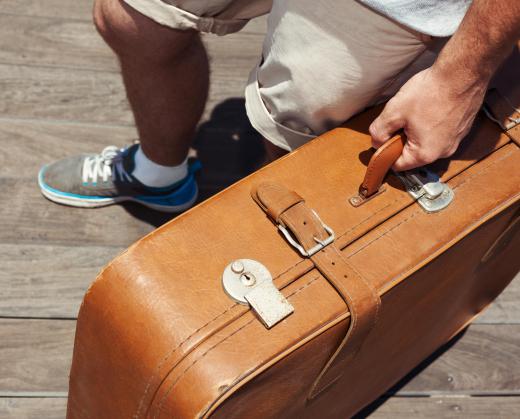 man-carrying-leather-luggage