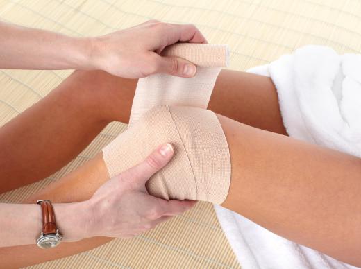 womans-knees-getting-wrapped-in-bandage